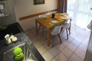 a kitchen with a wooden table and chairs and a table and a kitchen at Holiday resort Normandie Forges les Eaux Apartment for 5 pers in Forges-les-Eaux