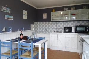 Holiday home in Criel sur Mer near sea في كرييل-سور-مير: مطبخ مع طاولة وكراسي زرقاء في مطبخ