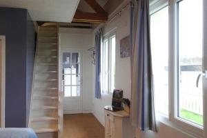 Holiday home in Criel sur Mer near sea في كرييل-سور-مير: غرفة بها درج وغرفة بها نوافذ