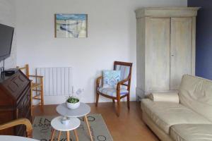 Holiday home in Criel sur Mer near sea في كرييل-سور-مير: غرفة معيشة مع أريكة وطاولة وكراسي