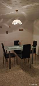 a dining room table with chairs and a chandelier at Apartma Arh in Rateče