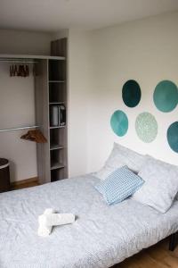 Schlafzimmer mit einem Bett mit blauen und grünen Kreisen an der Wand in der Unterkunft Duplex avec jardin - 2 parkings privés - 2 chambres in Cornebarrieu