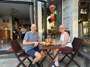 a man and a woman sitting at a table at Lisa homestay 2 in Hoi An
