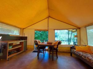 RoussinesにあるRomantic cottage with shared swimming poolのテント内のテーブルと椅子が備わる客室です。