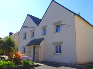 une maison blanche avec des étiquettes sur son côté dans l'établissement Modern semi detached house with terrace Saint Quay Portrieux, à Saint-Quay-Portrieux