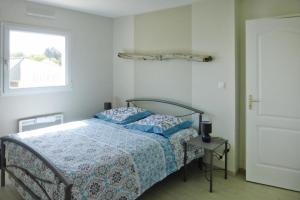 - une chambre avec un lit doté d'une couette bleue et d'une fenêtre dans l'établissement Modern semi detached house with terrace Saint Quay Portrieux, à Saint-Quay-Portrieux