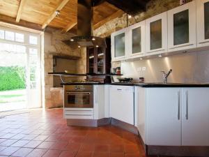 a kitchen with white cabinets and an oven at Warm Mansion with Swimming Pool in Sigoul s in Pomport