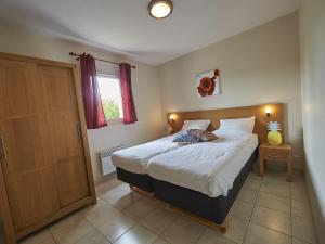 1 dormitorio con 1 cama y puerta de madera en Bungalow in Lanzac with Private Terrace en Lanzac
