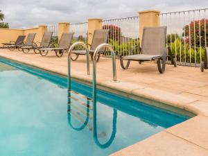 a row of chairs sitting next to a swimming pool at Modern holiday home in Aquitaine in Saint-Nexans