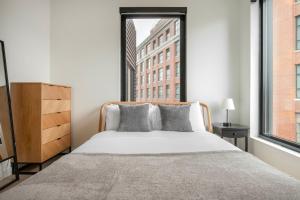 a bedroom with a bed and a large window at Blueground South Boston gym near T shops BOS-1024 in Boston