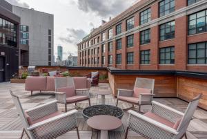 eine Terrasse mit Stühlen und Tischen sowie ein Gebäude in der Unterkunft Blueground South Boston gym near T shops BOS-1024 in Boston