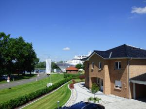 a building with a cruise ship in the background at Villa Kanalblick, Schiffsdeck in Oldenbüttel