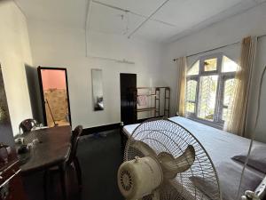 um quarto com uma cama, uma secretária e uma janela em Munin's Guest House em Jorhāt