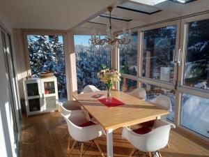 a dining room with a table and chairs and windows at Pine cones in the Haslehaus in Feldberg