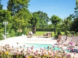 a woman sitting in chairs next to a swimming pool at Holiday Home in Saint Laurent de la Salle with Pool in La Chapelle-Thémer