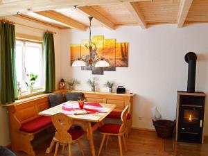 een eetkamer met een tafel en een fornuis bij Holiday home our little hunting lodge in Philippsreut