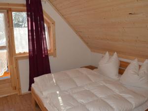 een slaapkamer met een wit bed op zolder bij Holiday home our little hunting lodge in Philippsreut