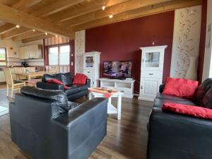 sala de estar con muebles de cuero negro y cocina en Holiday home Red Milan, en Irmenach