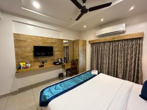Schlafzimmer mit einem Bett und einem Flachbild-TV in der Unterkunft Clarks Collection Somnath in Somnath