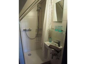 a bathroom with a shower and a sink and a mirror at Holiday apartment Strandkrabbe in Ockholm