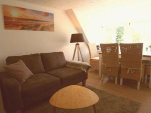 a living room with a couch and a table at Holiday apartment Strandkrabbe in Ockholm