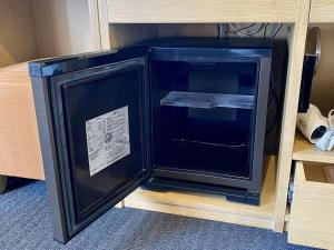 a small black refrigerator in a wooden shelf at Kansai Airport Washington Hotel in Izumi-Sano