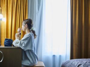 a woman sitting at a desk in a hotel room at Kansai Airport Washington Hotel in Izumi-Sano