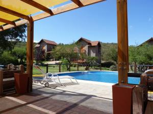 eine Terrasse mit Schaukel und Swimmingpool in der Unterkunft Complejo Pasos Malos in Merlo