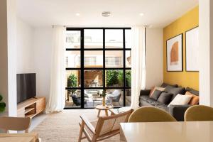 a living room with a couch and a tv at Lodging Apartments Rambla Poblenou 12 in Barcelona
