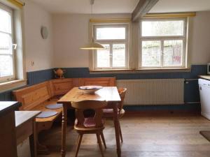 kuchnia ze stołem, krzesłami i oknami w obiekcie Holiday home gardener's house w mieście Unsleben