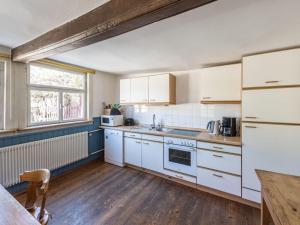 kuchnia z białymi urządzeniami i drewnianą podłogą w obiekcie Holiday home gardener's house w mieście Unsleben