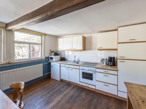 a kitchen with white appliances and a wooden floor at Holiday home gardener's house in Unsleben