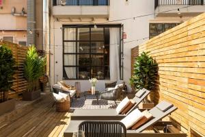 a patio with chairs and tables on a balcony at Lodging Apartments Rambla Poblenou 12 in Barcelona
