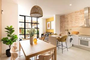 een keuken en een woonkamer met een tafel en stoelen bij Lodging Apartments Rambla Poblenou 12 in Barcelona