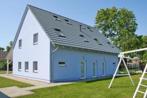 a blue and white building with a gambrel roof at Semi detached houses Hyggelig Seehausen in Seehausen