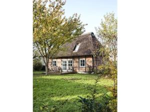 an old stone house with a thatched roof at Holiday home Kate keit in Altenhof