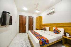 um quarto com uma cama e uma TV de tela plana em FabHotel Gazelle Inn em Gurgaon