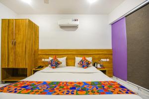 um quarto com uma cama grande e um cobertor colorido em FabHotel Gazelle Inn em Gurgaon