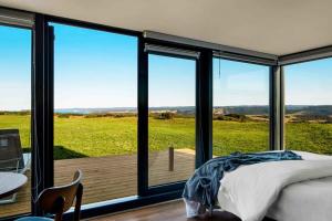 a bedroom with a bed and a view of a field at SKY SHIP 2 Luxury Off-Grid Eco Accommodation in Cape Otway