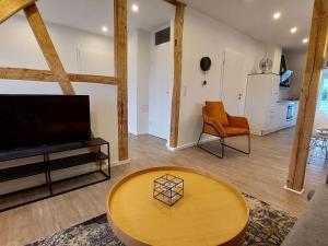 una sala de estar con un televisor y una mesa en Dornbusch Apartment 3, en Steinhude