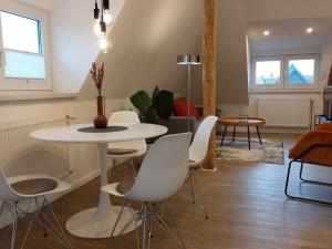 uma sala de estar com uma mesa e cadeiras brancas em Dornbusch Apartment 3 em Steinhude