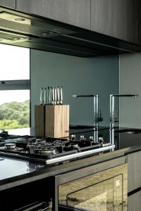 a kitchen with a stove top oven with a counter at Sky Pod 2 - Luxury Off-Grid Eco Accomodation in Cape Otway