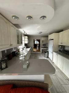 una gran cocina con armarios blancos y una gran isla en Executive Suite in a Victorian Style Bungalow P4b en Pickering