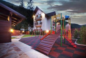 um parque infantil em frente a uma casa à noite em Vila Moldavia Class em Slănic-Moldova