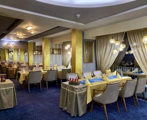 a dining room with yellow tables and chairs at Hotel Balkan in Pleven