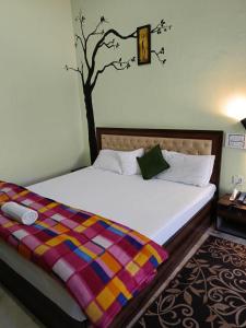 1 dormitorio con 1 cama con un árbol en la pared en Joshi Holiday Home Stay, en Lansdowne