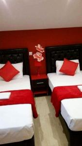 Habitación de hotel con 2 camas y paredes rojas en Apartmani Vesna Luxury & Stefan ap 4, en Paralia Katerinis