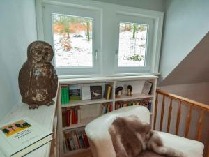 una habitación con un estante de libros y un búho sentado en una silla en Holiday home Waldhaus am Burbach en Bad Berleburg