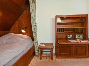 1 dormitorio con cama y escritorio con estantería. en Holiday home Waldhaus am Burbach en Bad Berleburg