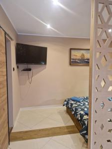 WILLA VASCO KOTWICA في ريوا: غرفة نوم مع سرير وتلفزيون بشاشة مسطحة على الحائط